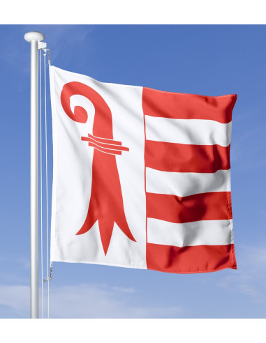 Le drapeau cantonal du Jura dans un vent fort contre un ciel bleu clair