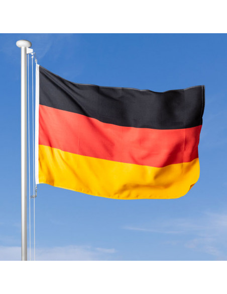Deutschland Fahne im Wind wehend am Fahnen-Mast, im Hintergrund blauer Himmel
