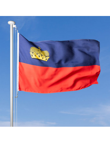 Fahne Fürstentum Liechtenstein im Wind wehend am Fahnen-Mast, im Hintergrund blauer Himmel